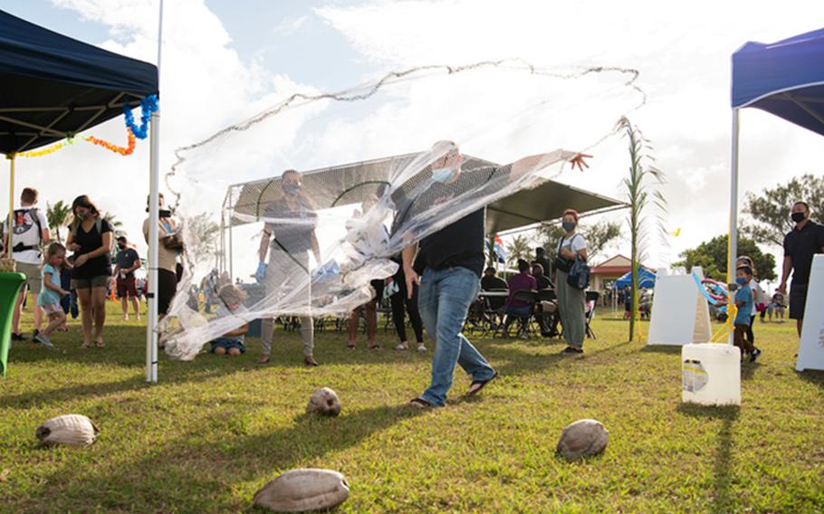 A participant throws a cast net over coconuts during the Tåotåo Guåhan event at Arc Light Memorial Park at Andersen Air Force Base, Guam, March 13, 2021. In honor of CHamoru Month, the Andersen AFB community hosted an event to celebrate the island’s indigenous culture and heritage with members of the base and local residents in attendance. (U.S. Air Force photo by Senior Airman Aubree Owens)