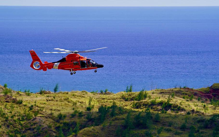 An MH-65 Dolphin helicopter crew deployed to Guam from U.S. Coast Guard Air Station Barbers Point in Hawaii flies patterns to assess winds and terrain before conducting rescue hoist training at Sella Bay Overlook in Guam on March 8, 2023. Eight members of GFD's Battalion A worked with the aircrew and personnel from the U.S. Coast Guard Forces Micronesia/Sector Guam response department. (U.S. Coast Guard photo by Chief Warrant Officer Sara Muir)