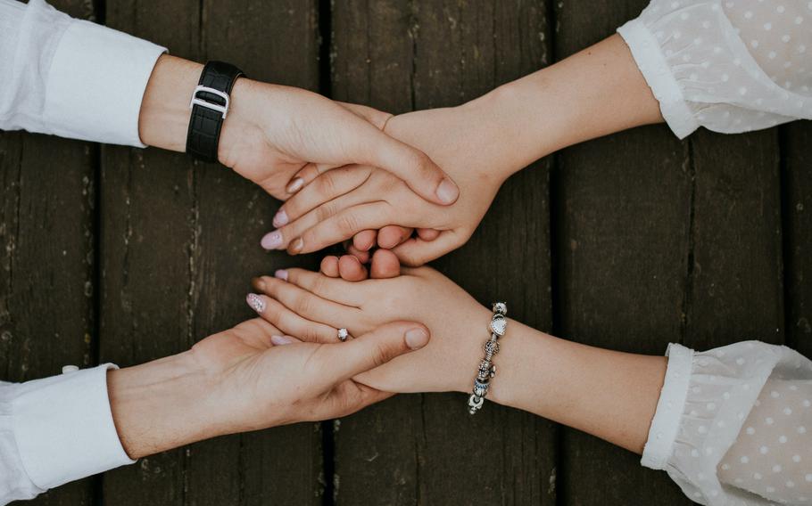 Two people holding both hands