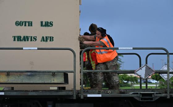 U.S. Air Force Airmen assigned to the 44th Aerial Port Squadron and 734th Air Mobility Squadron push a load off of a running C-17 Globemaster III during engine running offload training。