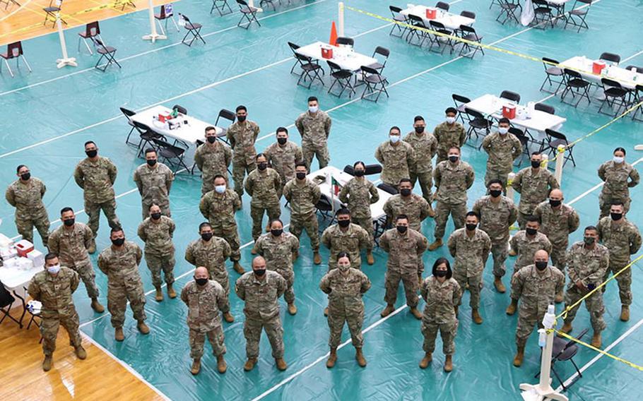 Members of Task Force Medical and Task Force Response, under the Guam National Guard’s Joint Task Force 671 and in support of the Guam Department of Public Health and Social Services, form up for a pre-shift brief at the University of Guam Calvo Field House in Mangilao Guam on Feb. 26, 2021. The crew of approximately 40, with help from the University of Guam, DPHSS and community volunteers, can administer over 1,500 COVID-19 vaccine doses per day under Operation Liberate Guam. (Mark Scott/GUNG)