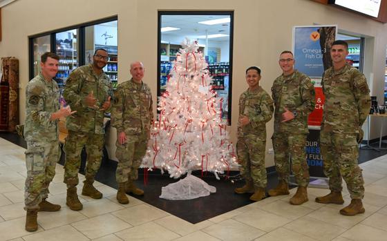 Photo Of First Sergeants from the Andersen First Sergeant Council on Andersen Air Force Base, Guam, pose next to the Angel Tree at the Base Exchange, Andersen AFB, Guam, Dec. 3, 2024.