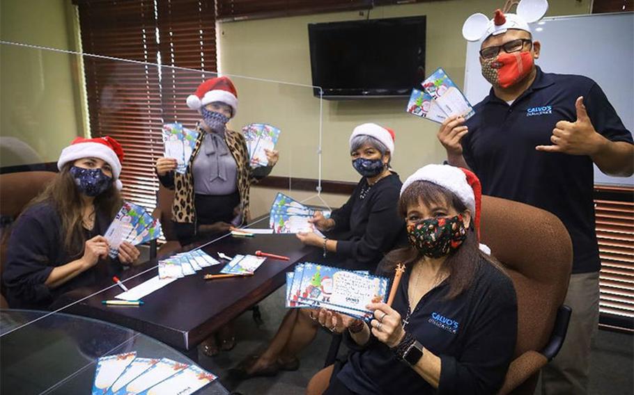 Calvo's employees finish writing their Christmas cards for Guam’s foster families. The cards were attached to CPK gift cards and delivered to Harvest House for the families. From left, Calvo’s Insurance employees Bertha Cabrera, Janice Lynn Reyes, Therese Toves, Agnes Matanane, and Manuel Lujan.