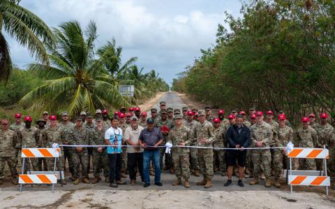 Photo Of 513th Expeditionary Rapid Engineer Deployable Heavy Operations Repair Squadron Engineers Squadron, U.S. Navy Seabees, U.S. Marine engineers, and members of the Tinian Municipal Council pose in front of Broadways Street during a ribbon cutting at Tinian’s North Field, Tinian.