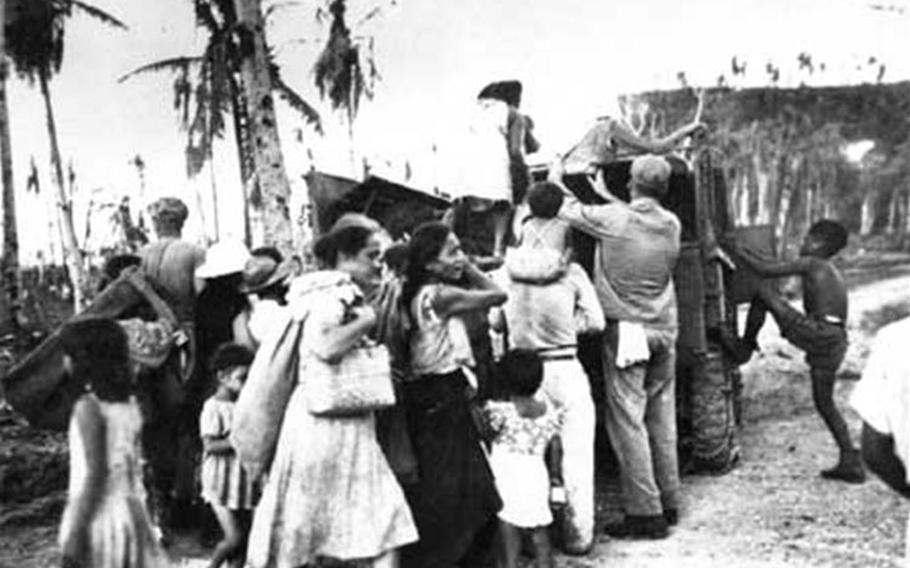 Marines assisting them, people begin to load themselves and whatever belongings they had aboard a truck. This was the kind of scene typical in the liberation as U.S. military officials began to restore order to the island. Photos courtesy of War in the Pacific National Historic Park