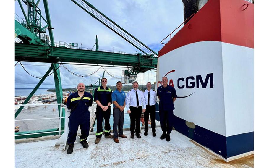 At the Port of Guam on Aug. 10, 2022, Capt. Nick Simmons, U.S. Coast Guard Forces Micronesia/Sector Guam commander, stands for a photo Capt. Donald Moore and the crew who were present during the case, as well as Charlie Hermosa, general manager in Guam for CGA CGM and APL. The U.S. Coast Guard recognized mariners aboard the CGA CGM Herodote with a Certificate of Merit for their action to save lives back in March. (U.S. Coast Guard photo by Chief Warrant Officer Sara Muir)