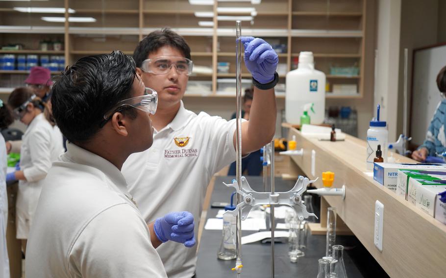 Everett Singleton of Father Dueñas Memorial School measures a solution with his teammate, Bernard Malicsi, during the 2023 Chemistry Titration Competition on March 2 at the University of Guam. The pair won third place for “Best Team.”