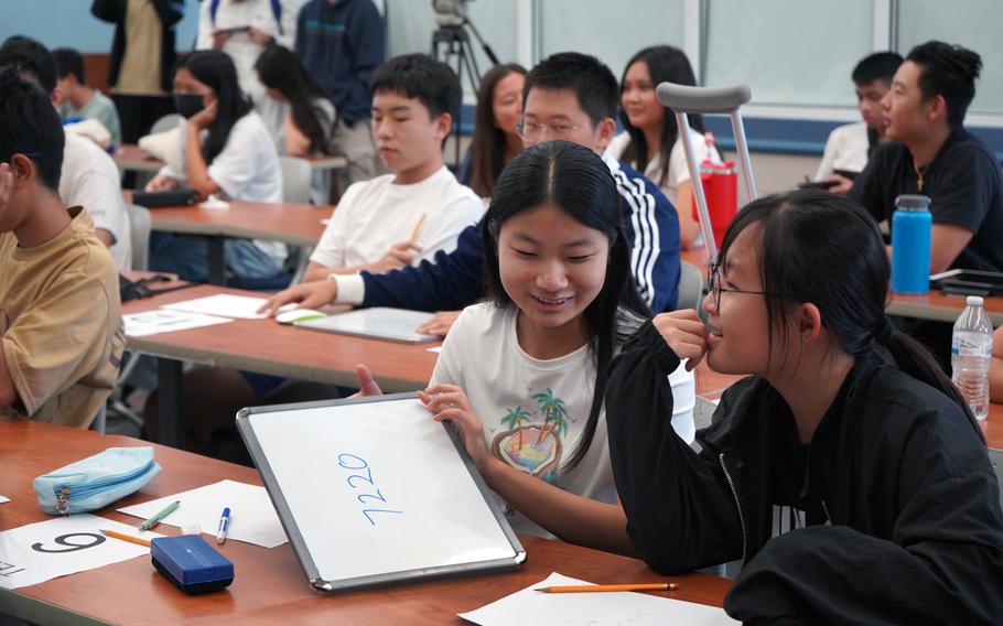 Yaxin Liu, left, and Celina Kim from Harvest Christian Academy collaborate on their answer during the high school algebra, geometry, and statistics quiz competition at UOG’s Math Day.