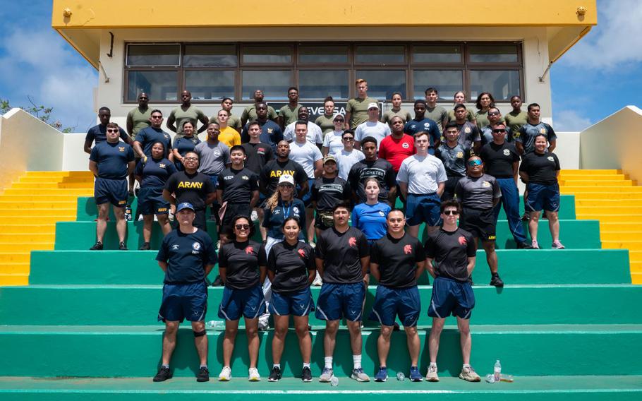 U.S. Air Force, Army, Marine Corps and Navy service members pose with Junior Reserve Officer Training Corps instructors from John F. Kennedy High School, Guam, in Tamuning, Guam, Feb. 24, 2024. These 49 volunteers made sure more than 100 cadets were able to complete all six challenges smoothly and scored fairly within DoD physical fitness assessment standards. Although the event was called a challenge, the true purpose of the JROTC Fitness Challenge is to allow natural mentoring opportunities between the volunteers and cadets.