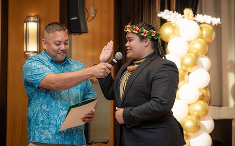 Photo Of Devin Calvo Santos (right), takes the oath of office as Student Regent with University of Guam Board of Regents Chairperson Agapito “Pete” Diaz (left) presiding during the SGA inauguration ceremony.