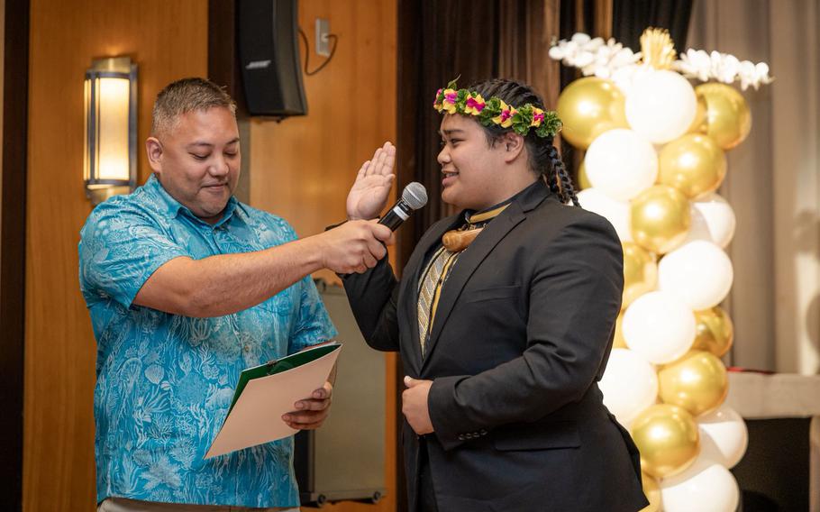 Devin Calvo Santos (right), takes the oath of office as Student Regent with University of Guam Board of Regents Chairperson Agapito “Pete” Diaz (left) presiding during the SGA inauguration ceremony.