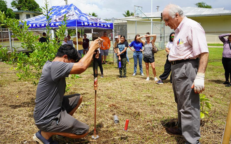 Research associate Ferdinand Galsim, left, and UOG soil scientist Dr. Mohammad Golabi demonstrate how to take a soil sample at a soil workshop for farmers.