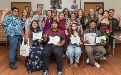 Photo Of L-R front row: Awardees Francine Cruz, Franklin Fujihira, Katielyn Aizon, and Caleb Cruz surrounded by family, friends, UOG administrators, and the family members of the CHamoru authors and songwriters who were honored through the awards.