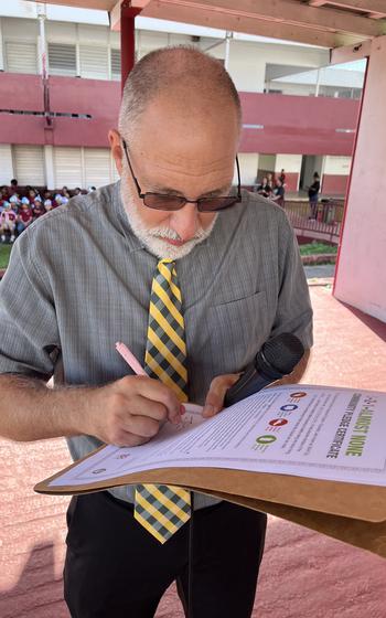 John Wesolowski, principal of H.B. Price Elementary School, signs the 5-2-1-Almost None pledge at a school ceremony on Nov. 4, 2024.