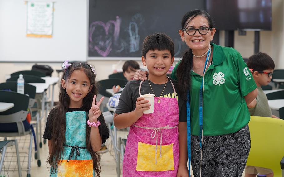 UOG Land Grant extension associate Clarissa Barcinas, right, poses with two 4-H summer camp participants in June 2025 and the new cooking aprons they sewed.
