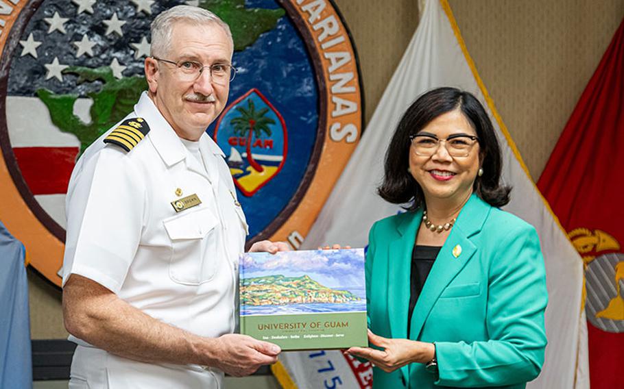 University of Guam President Anita Borja Enriquez and Capt. Troy Brown, Commanding Officer of Naval Facilities Engineering Systems Command Marianas, lead the signing of the Memorandum of Understanding to formalize an internship pathway for UOG’s engineering students with NAVFAC. After the signing, Dr. Enriquez, right, presents Capt. Brown with a coffee table book about UOG at NAVFAC Marianas on Nimitz Hill on Nov.1, 2023. Photos courtesy UOG