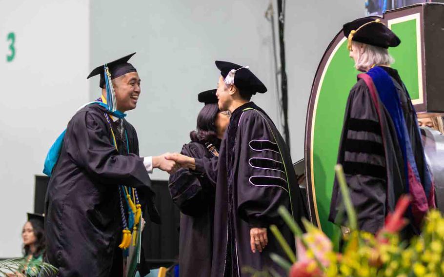 Master of Public Administration graduate Evander De Guzman greets UOG Board of Regents Chairperson Lesley-Anne Leon Guerrero as he walks across the stage at the University of Guam’s Fañomnåkan (Spring) 2025 Commencement Ceremony at the Calvo Field House on May 25.