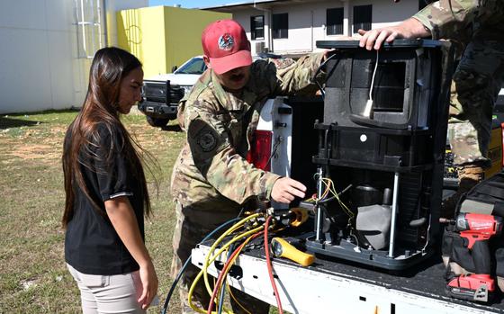 U.S. Air Force Tech. Sgt. Ronald Gottus, 554th Rapid Engineer Deployable Heavy Operational Repair Squadron Engineers Squadron, explains how an Air Conditioning Unit operates to a student at Tiyan High School, Guam