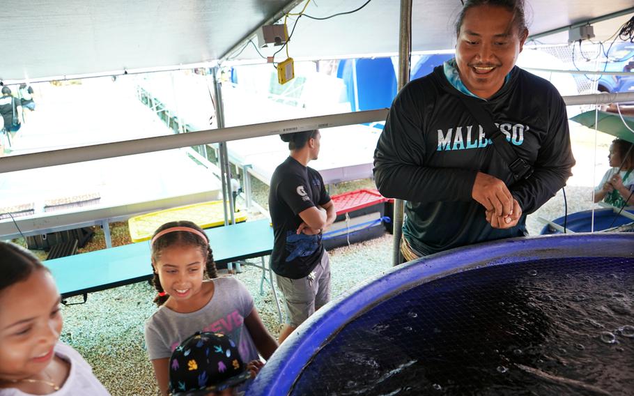 Johnny Borja, an associate with UOG Sea Grant, shows children visiting the University of Guam for Charter Day the tilapia tanks in the new CNAS Aquapark on March 7.