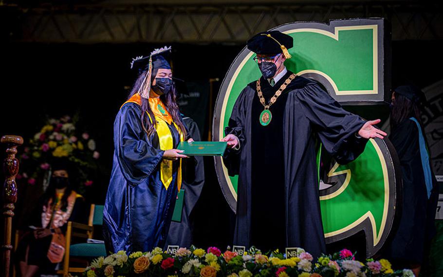 A graduate receives her diploma from UOG President Thomas W. Krise while crossing the stage at the University of Guam Fañomnåkan Commencement Ceremony on May 23, 2021. Photos courtesy of the University of Guam