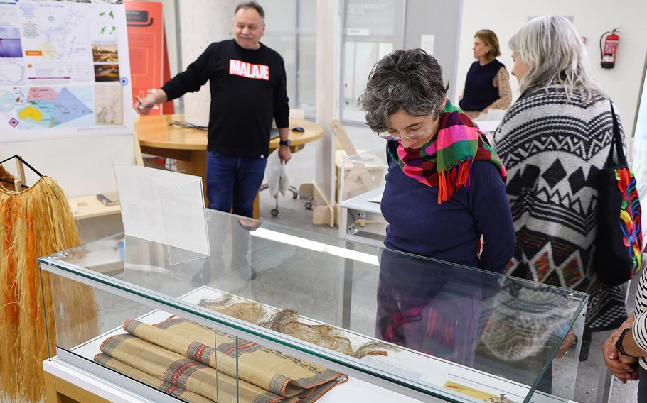 Beatriz Moral (center), curator of the exhibit, looks at artifacts from Yap given to Del Valle in the 1970’s.