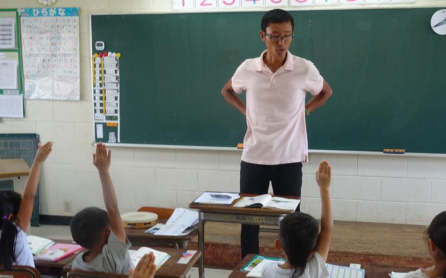 students raising hands during class