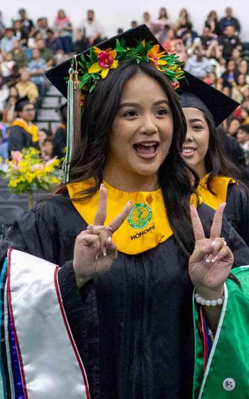 Business Administration major Thelma Grace Rogers celebrates as she walks towards the stage to receive her diploma during the University of Guam Fañomnåkan (Spring) 2025 Commencement Ceremony at the Calvo Field House on May 25.