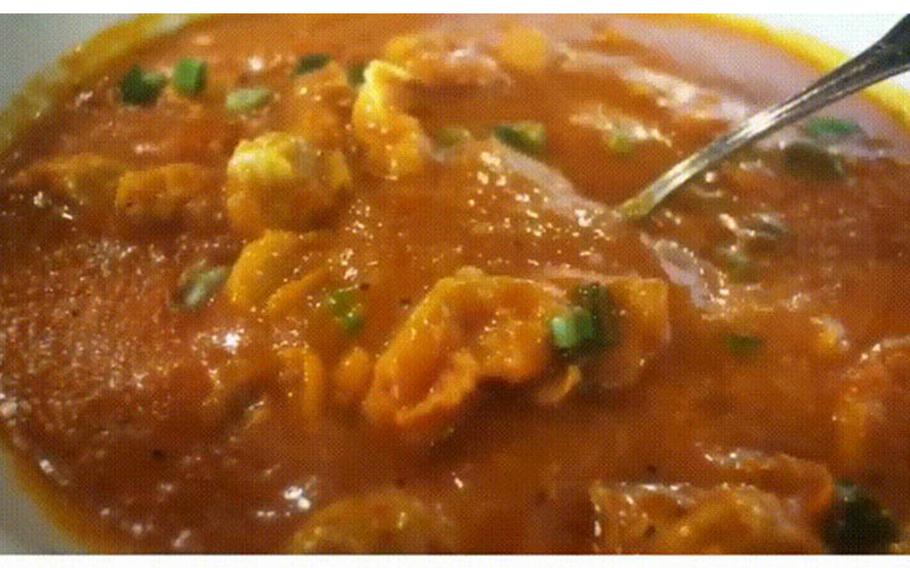 Scooping chicken chalakiles with a spoon.
