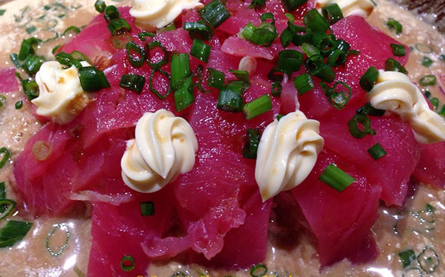 A full close-up photo of sashimi with mayonnaise.