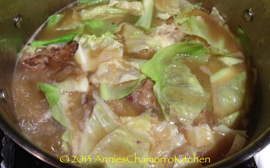 First, layer the cabbage on top of the ribs. Press down on the cabbage, just slightly so that the leaves are moistened with the broth.