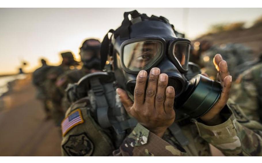 Army Command Sgt. Maj. Shelita Taylor, command sergeant major of the 400th Military Police Battalion, dons and clears her gas mask during a team-building ruck march held by the 200th Military Police Command (Photo by: Army Reserve Master Sgt. Michel Sauret).