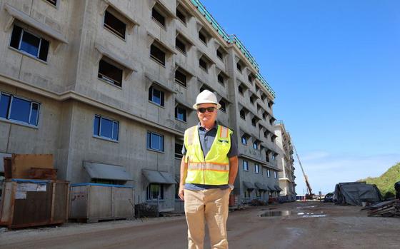 Lamarcus Blount, an Engineering Technician at the Office in Charge of Construction (OICC) Marine Corps Marianas, poses for a photo in front of Bachelor Enlisted Quarters (BEQs) under construction on Marine Corps Base Camp Blaz in January.