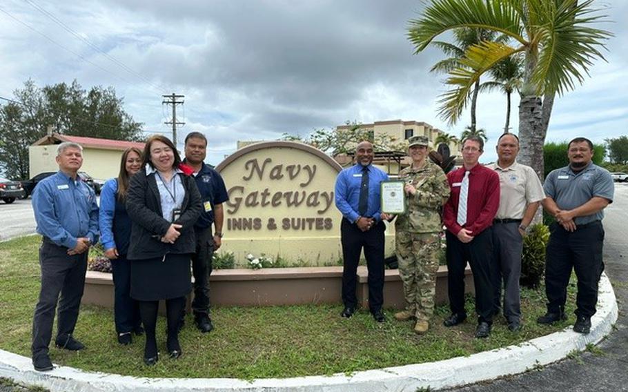 Navy Gateway Inn & Suites group photo as Stars and Stripes Pacific Commander Lt. Col. Marci Hoffman presents Best on-base lodging award to NGIS staff.