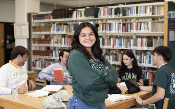 Photo Of A student is smiling in the library.