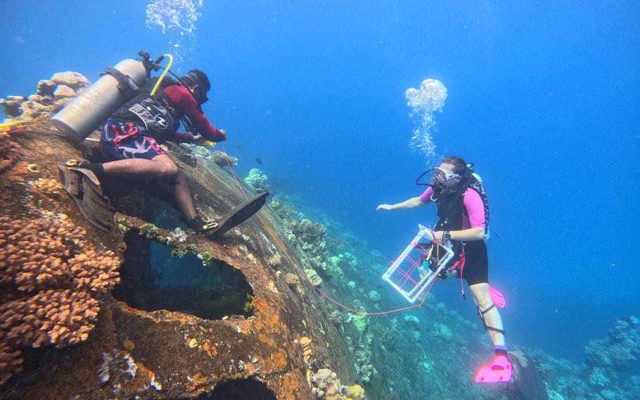 Kalle Applegate-Palmer, in pink fins, and Chioshy Topias survey the Heian Maru shipwreck in July 2023. Palmer is a marine ecologist and Topias is with the Chuuk Historic Preservation Office.