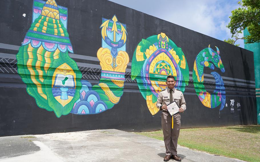 Lidio Fullo, co-valedictorian of the University of Guam Class of Fañomnåkan 2024, stands by the UOG mural outside the Calvo Field House before the commencement ceremony on May 19.