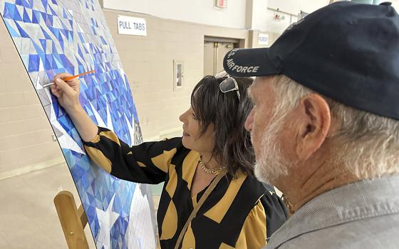 Photo Of a woman is painting and a man is beside her.