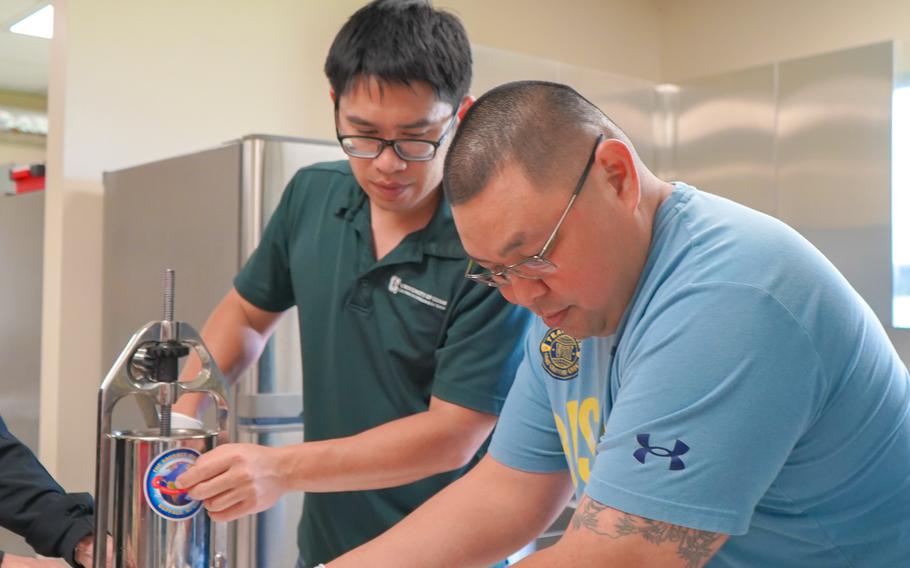 Marvin Crisostomo and Dr. Jeng-Hung Liu, meat scientist with the University of Guam Land Grant Extension Service, feed pork into sausage casings during a meat processing workshop held in August 2023 at UOG.