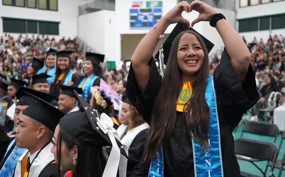 Photo Of Elementary education major Naomi Jean Blas sends love to her family in the bleachers during the University of Guam Fanuchånan 2024 Commencement Ceremony on Dec. 15 at the Calvo Field House.