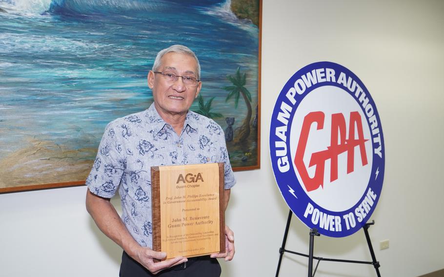 GPA GM John M. Benavente, P.E. holds the award by the wall.