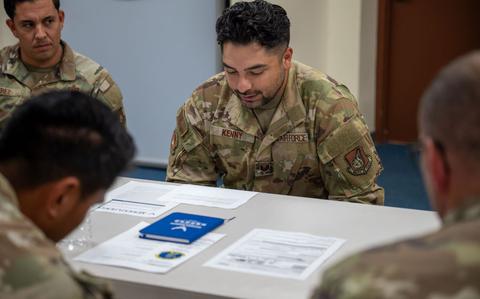 Photo Of U.S. Air Force Tech. Sgt. Christopher Kenny is reading a document in a First Sergeant Symposium.