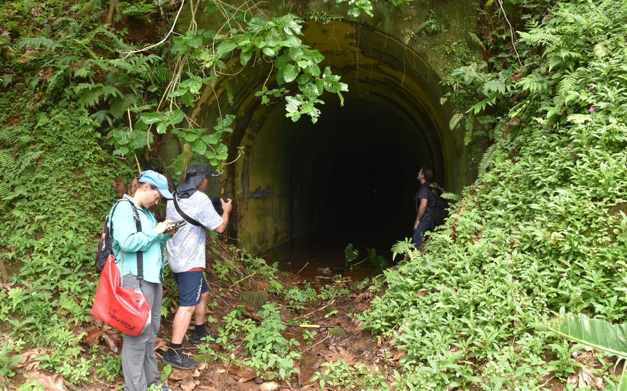 Team members who surveyed wartime relics on Tonoas island, formerly called Natsushima during Japanese times. From left, Maria Kottermair, Geographic Information Systems Specialist; Greg Adams, photographer; and Dr. David Atienza, UOG Professor of Anthropology. They are seen at the entrance to the 120-meter-long bunker that Japanese communications operations during World War II.