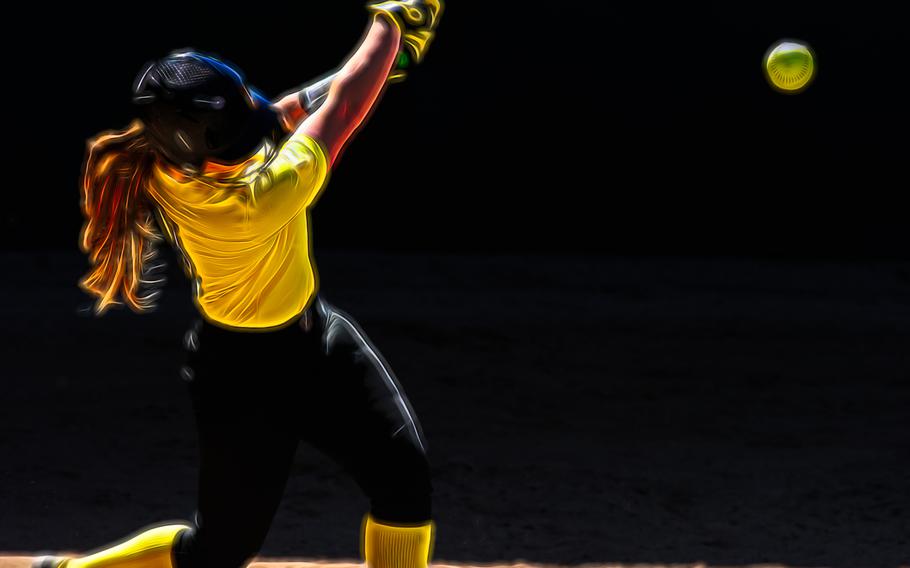 A female softball player is batting swinging for the fences.