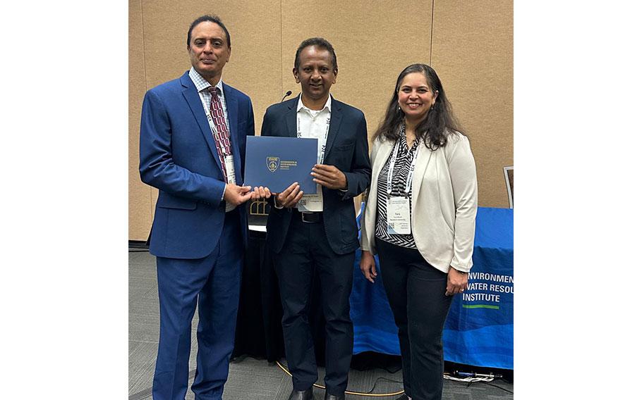 Dr. Hiroshan Hettiarachchi and two people pose for a photo.
