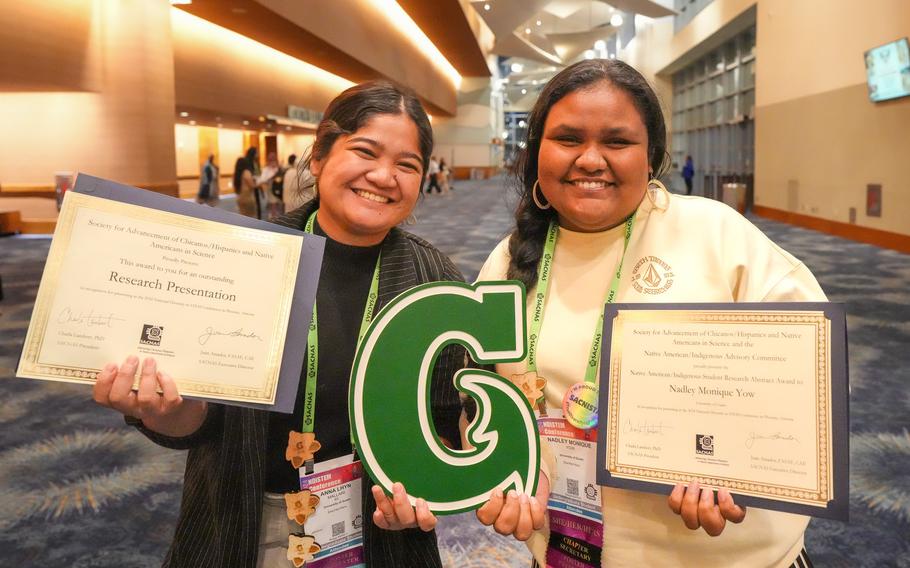 Anna Mallari and Nadley Yow pose with the awards in their hands.