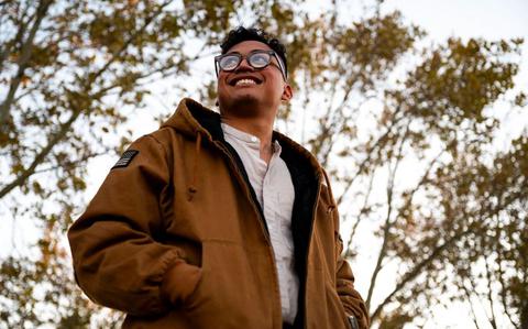 Photo Of Senior Airman Kiersten Fausto poses for a photo. some trees can be seen behind him.