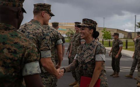 Photo Of U.S. Marines congratulate Capt. Lara DeLeon smilingly shakes hands with some other military personnel.