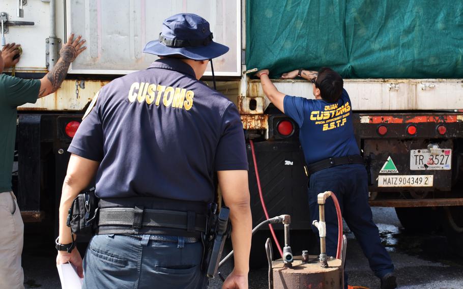 Guam Customs and Quarantine Agency Biosecurity Task Force officers provide oversight of fumigation and inspection protocols on a shipping container of fresh Christmas trees on Dec. 2, 2024 at a local business establishment in Tamuning.