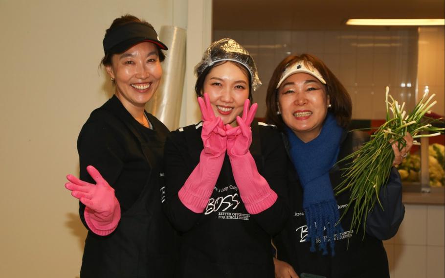 three ladies pose in the kitchen.