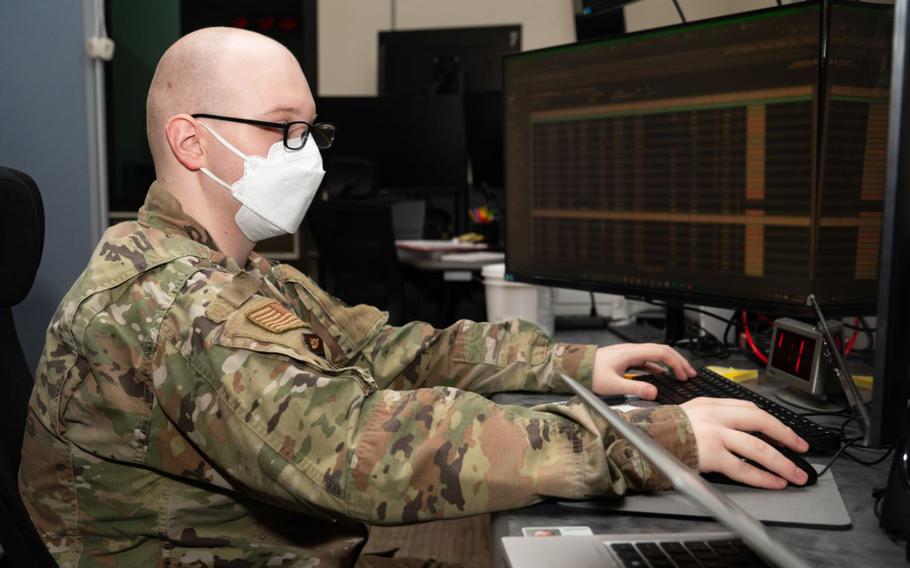 Senior Airman Andrew Vance with mask is typing in the office.